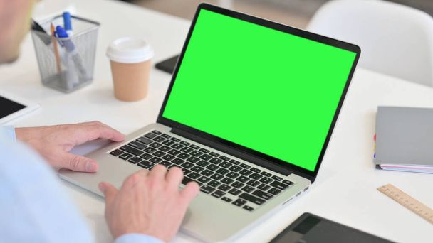 Yeşil Krom Ekran ile Orta yaşlı adam dizüstü bilgisayar kullanıyor - Fotoğraf, Görsel