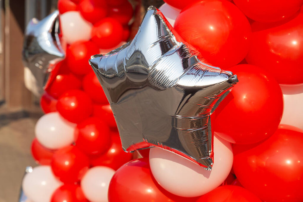 Des ballons rouges et un premier en forme d'argent. Vacances ou événement concept de décoration de rue - Photo, image