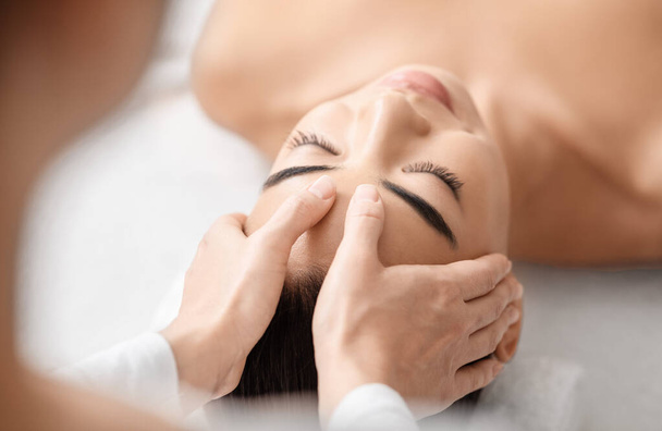 Mladá atraktivní korejská žena dostává akupresurní masáž v lázeňském salonu - Fotografie, Obrázek
