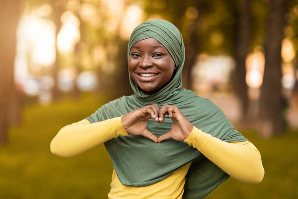 Liebe. Lächelnde afrikanische Muslimin im Hijab zeigt Herz-Geste - Foto, Bild