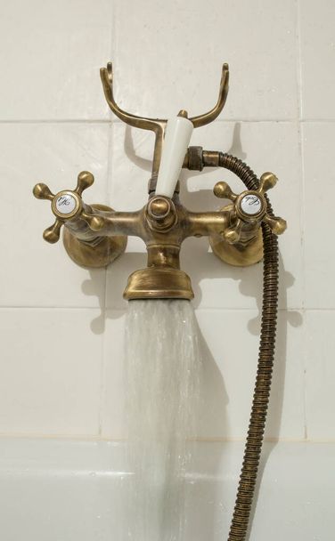 Grifo de tubo de baño de cobre antiguo abierto. chorro de agua - Foto, imagen