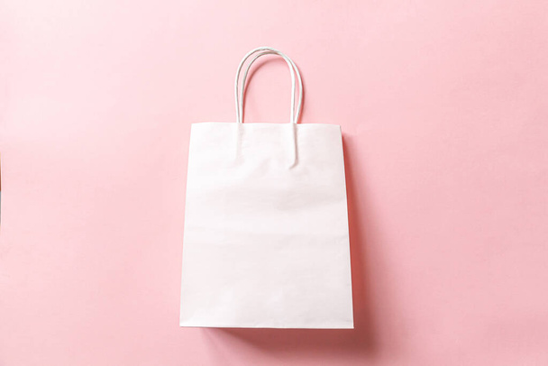 Simply minimal design shopping bag isolated on pink pastel background. Online or mall shopping shopaholic concept. Black friday Christmas season sale. Flat lay top view copy space mock up - 写真・画像
