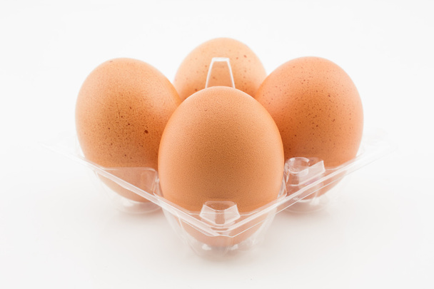 cztery jajka w plastikowej tacce na białym tle - Zdjęcie, obraz