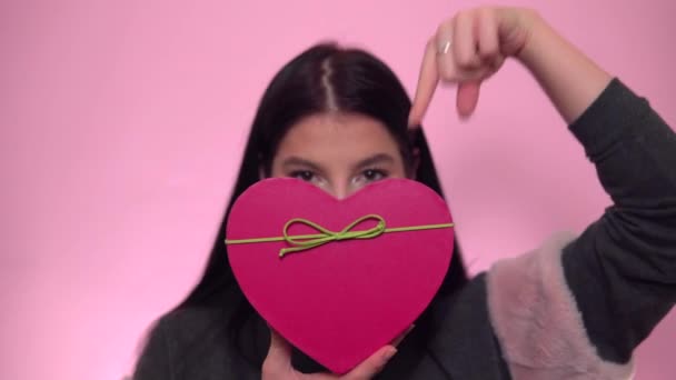 Η ιδέα του Αγίου Βαλεντίνου. Γυναίκα με την καρδιά παρούσα κουτί σε ροζ φόντο - Πλάνα, βίντεο