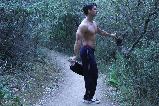 El hombre está haciendo ejercicio al aire libre mostrando sus músculos. - Foto, imagen