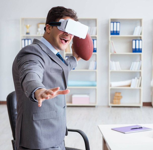 Επιχειρηματίας που παίζει ποδόσφαιρο εικονικής πραγματικότητας στο γραφείο με VR g - Φωτογραφία, εικόνα