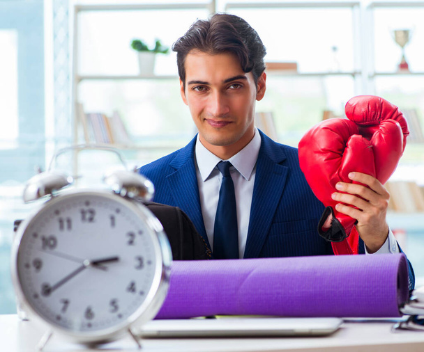 Человек в боксёрских перчатках в офисе - Фото, изображение