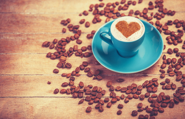 Kaffeetasse mit Herzform auf einem Holztisch. - Foto, Bild