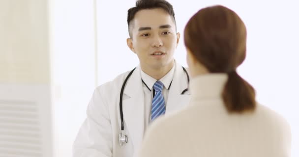 mężczyzna lekarz wyjaśniający diagnozę kobiecie - Materiał filmowy, wideo