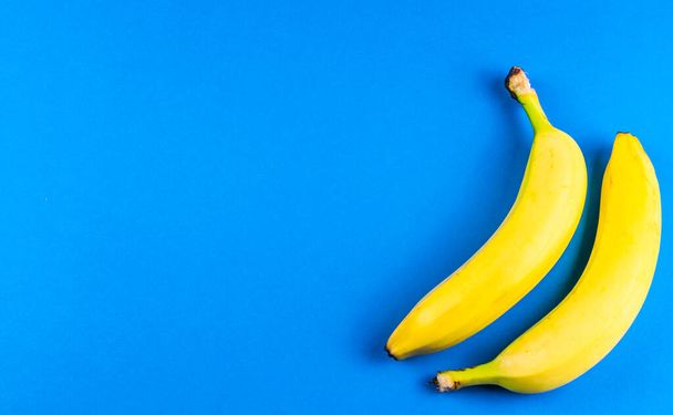 macro photo of yellow bananas over blue background - Fotó, kép