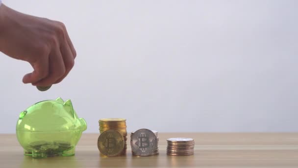 Ένα χέρι που κρατά ένα νόμισμα σε ένα κουμπαρά για να εξοικονομήσει χρήματα στο μέλλον - Πλάνα, βίντεο