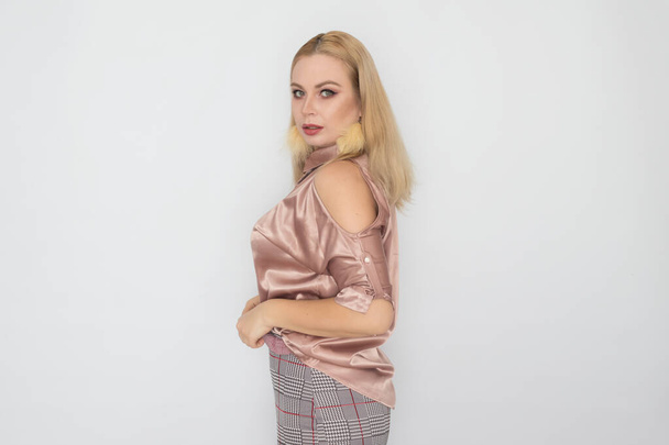 Smiling blonde business woman in pink blouse over white background - Fotó, kép