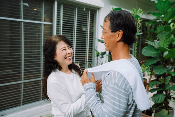 Azji stary para sprzątanie ciała z ręcznikiem po treningu sportowym razem w domu. - Zdjęcie, obraz