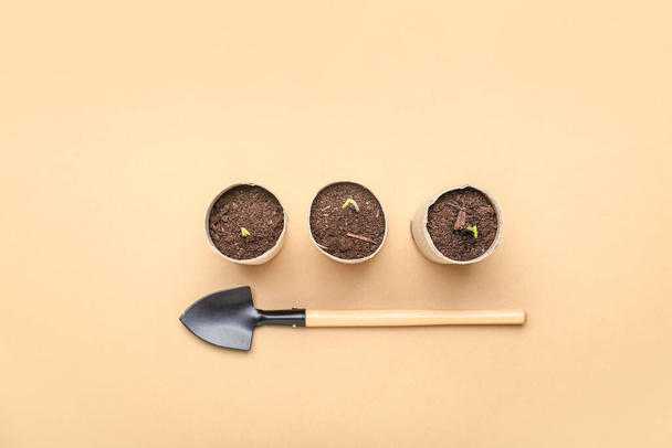 Peat pots with soil and green seedling on color background - Photo, Image