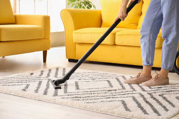 Frau putzt schönen Teppich im Wohnzimmer - Foto, Bild