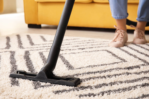 Donna pulizia bellissimo tappeto in soggiorno - Foto, immagini