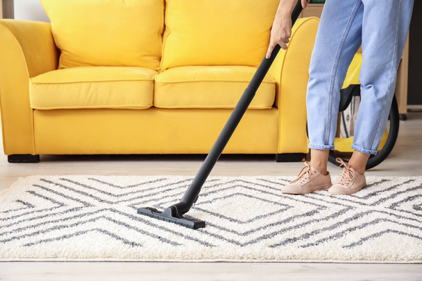 Woman cleaning beautiful carpet in living room - Photo, image