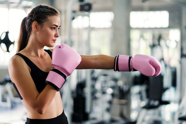 Young beautiful woman with boxing gloves exercise in fitness gym. - Φωτογραφία, εικόνα