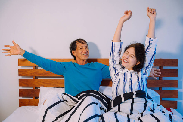 Asian senior couple wake up in the morning in bedroom. - Foto, Imagen