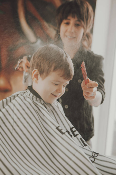 El trabajo de la barbería. Corte de pelo de un niño en una peluquería. Corte de pelo infantil - Foto, imagen