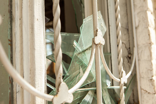 Sérült ablak törött üveggel egy régi elhagyatott házban. Egy törött üvegablak egy elhagyatott házban.. - Fotó, kép