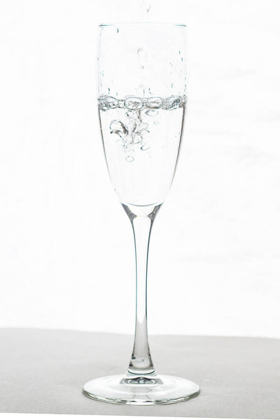 Plnění skleněné vody šampaňského izolované na bílém pozadí - Fotografie, Obrázek