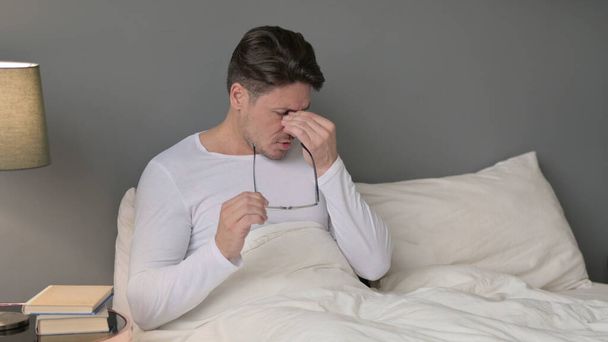 Homem de meia-idade estressado com dor de cabeça na cama - Foto, Imagem