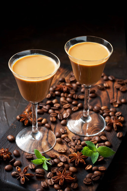 Liqueur with coffee and vanilla. Liqueur in small glasses on the dark table with coffee beans - Foto, Imagen