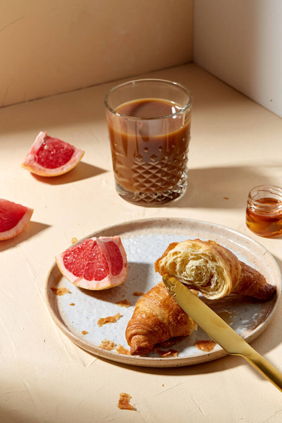 glass of coffee, croissant and grapefruit on table - Φωτογραφία, εικόνα