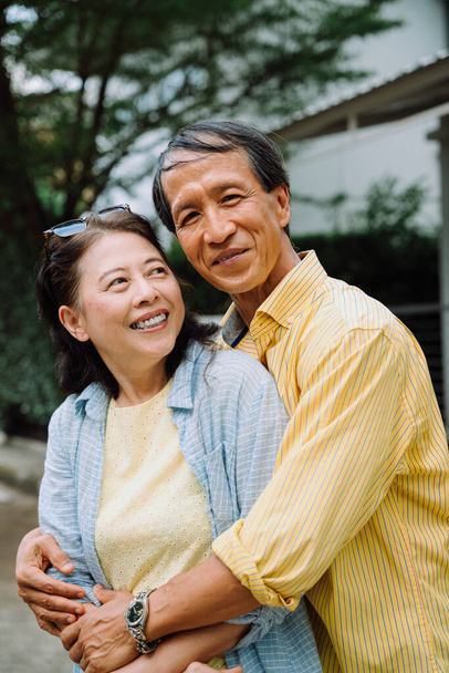 Portrait de asiatique senior couple étreignant à l'extérieur dans la cour arrière. - Photo, image