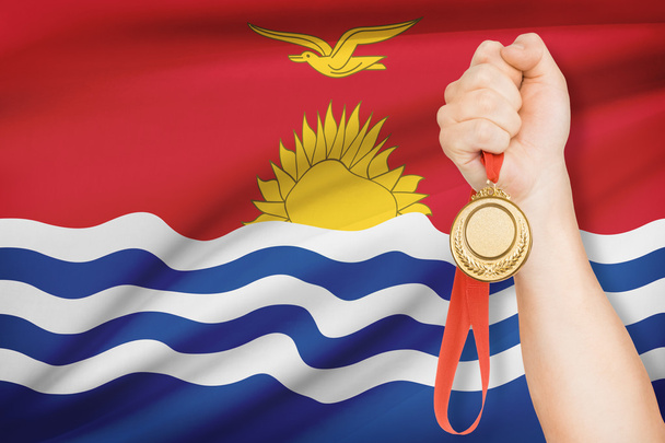 μετάλλιο στο χέρι με σημαία σε φόντο - Δημοκρατία του Κιριμπάτι - Φωτογραφία, εικόνα