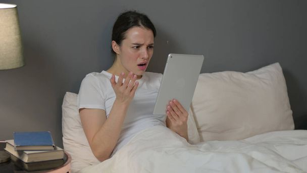 Young Woman Reacting to Loss on Tablet in Bed  - Фото, зображення