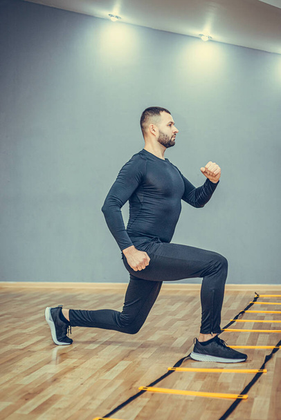 Fitness-Konzept. Porträt eines gutaussehenden Mannes beim Laufen und Planken im Fitnessstudio. - Foto, Bild