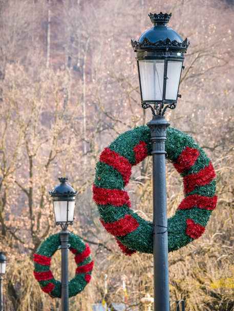 Antiguo poste de lam vintage o lámpara de calle decorada con adorno de pino de corona de Navidad en Sinaia ciudad, Rumania. - Foto, imagen