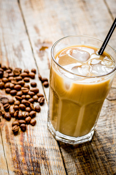 木製の背景に冷たい夏の飲み物のための豆とアイスコーヒー - 写真・画像