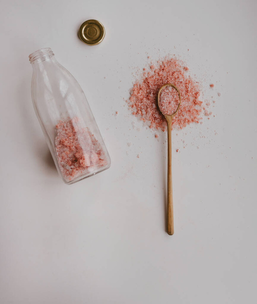 vaaleanpunainen suola valkoisella pöydällä puisessa lusikassa - Valokuva, kuva