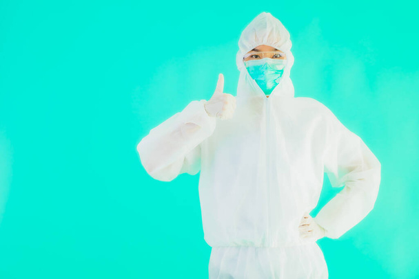 Retrato hermosa joven asiática médico mujer usar ppe o equipo de protección personal para proteger de coronavirus o covid19 con tarjeta vacía pizarra blanca sobre fondo aislado azul
 - Foto, imagen