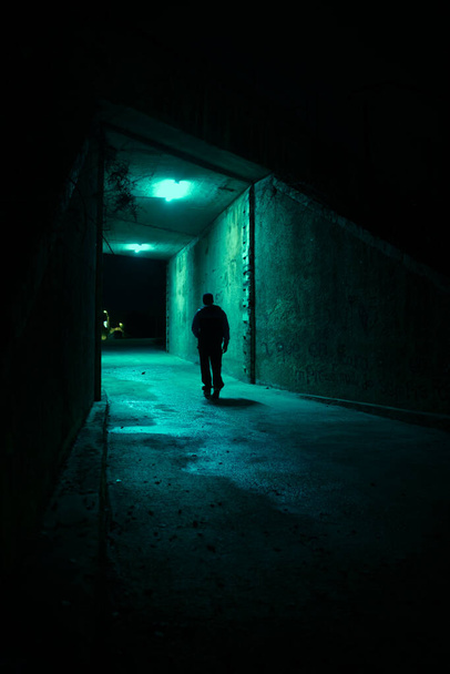 Lonely man in a dark alley at night. Danger and scary concept. - Фото, изображение