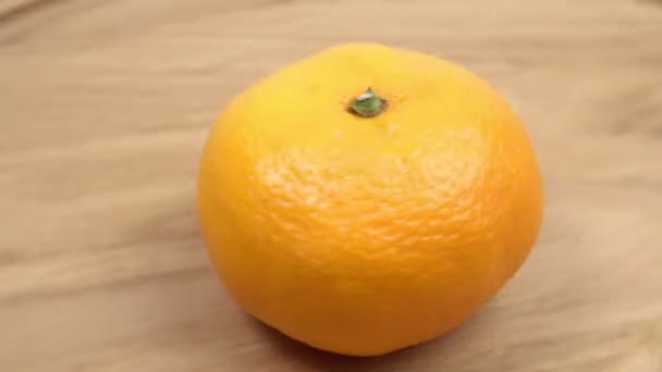 tangerina fruta fechar-se girando em um fundo de madeira - Filmagem, Vídeo