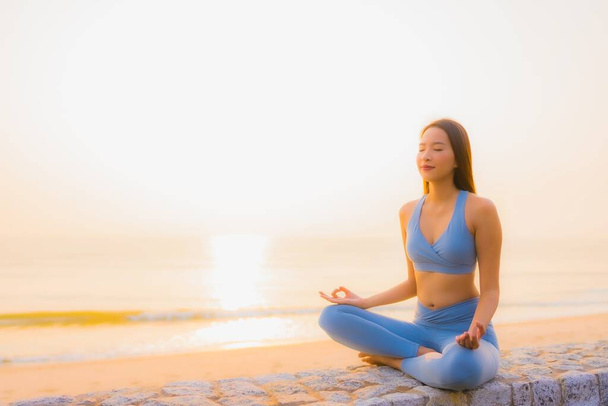 Ritratto giovane donna asiatica fare meditazione intorno mare spiaggia oceano al sorgere del sole per salute - Foto, immagini