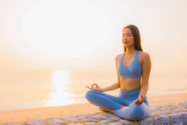 Retrato joven asiático mujer hacer meditación alrededor de mar playa océano al amanecer para la salud - Foto, Imagen