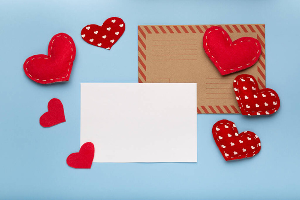 Valentines Day background. Red hearts, paper blank on pastel blue background. Love letter concept, copy space - 写真・画像