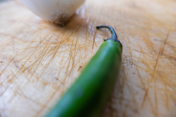 Świeża papryka chili i cebula wyizolowane na drewnianym stole - Zdjęcie, obraz