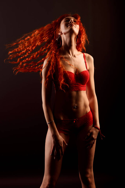 Redhead sexy cabaret dancer in lingerie on dark background, free space for your text - Fotó, kép
