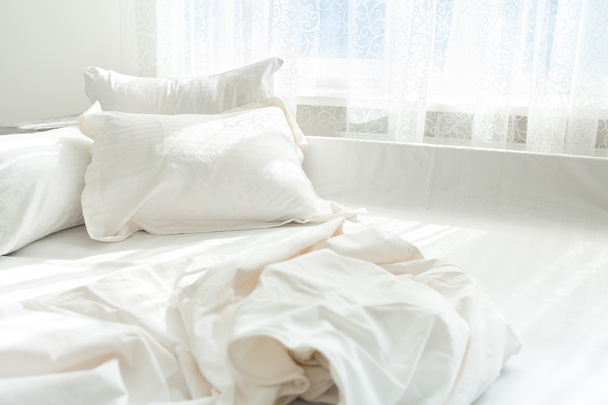 Kuva epäsiististä sängystä ikkunaa vasten
 - Valokuva, kuva