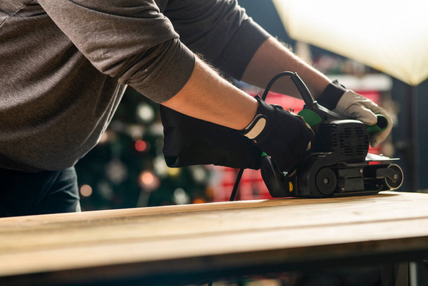 Carpinteiro trabalha com lixadeira de cinto em carpintaria - Foto, Imagem