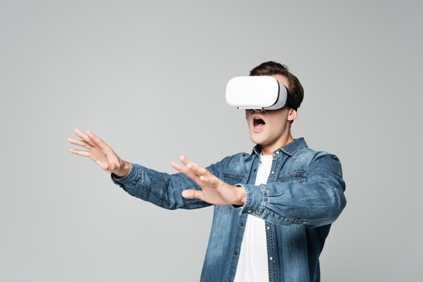 Excited man using vr headset isolated on grey - Photo, Image