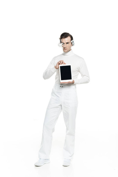 Киборг в наушниках и объективах для глаз с цифровым планшетом с чистым экраном на белом фоне - Фото, изображение