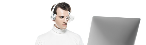 Brunette cyborg man in headphones and eye lens looking at computer monitor isolated on white, banner - Photo, Image