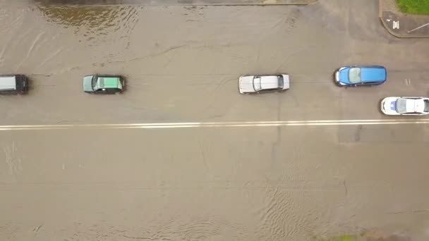Sel basmış yolda yağmur suyu ile giden trafik arabalarının hava görüntüsü. - Video, Çekim